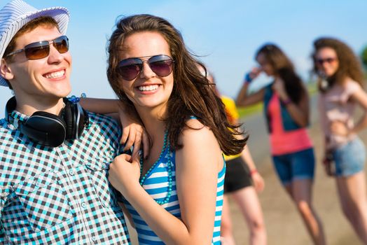 young couple standing on the road, having fun with friends