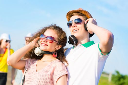 young couple standing on the road, having fun with friends