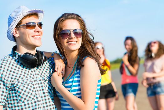 young couple standing on the road, having fun with friends