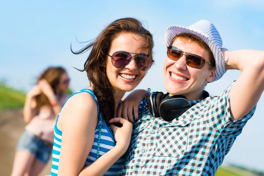 young couple standing on the road, having fun with friends