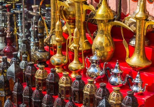 row of shiny traditional coffee pots and lamp at the souq in Dubai.