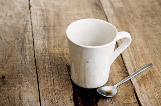 Empty coffee mug, with stains on wooden background