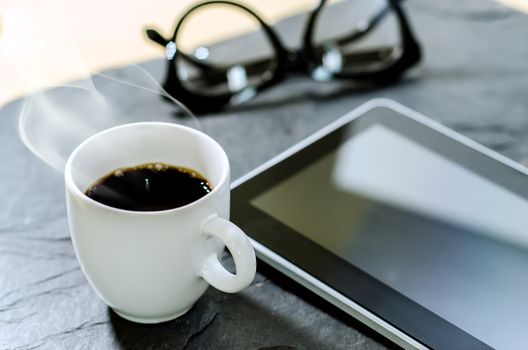 Coffee cup ,glasses and tablet on stone table