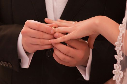 A man gives a woman a wedding ring on her finger
