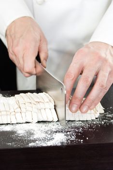 Close-up of a Chef cutting fresh pasta.