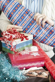 Close-up of a man unrolling wrapping paper for christmas presents.