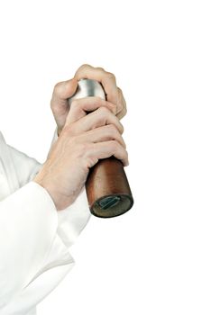 Close-up of a chef using a pepper mill to season his food; side facing, arms only.