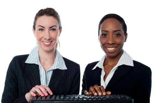Two female executives typing on keyboard