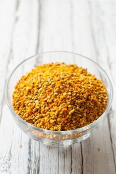 raw organic bee pollen over wooden board