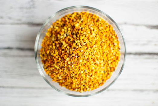 raw organic bee pollen over wooden board