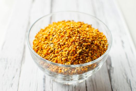 raw organic bee pollen over wooden board