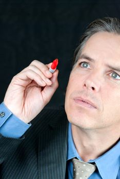 Close-up of a worried businessman writing on the fourth wall with a red marker