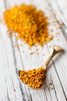 raw organic bee pollen over wooden board