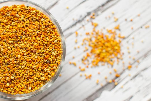 raw organic bee pollen over wooden board