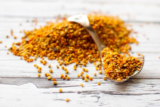 raw organic bee pollen over wooden board