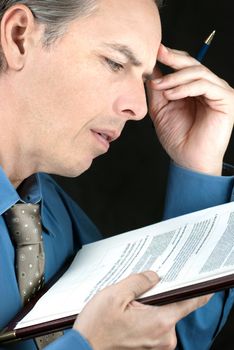 Close-up of an stressed businessman reading a document.