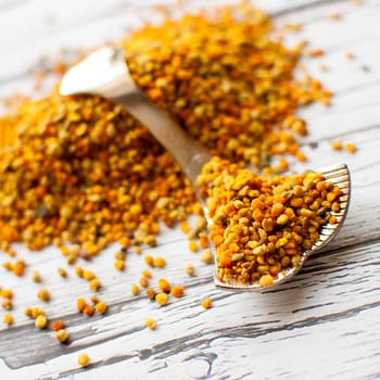 raw organic bee pollen over wooden board