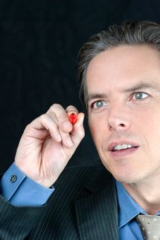 Close-up of an intense businessman writing on the fourth wall with a red marker.