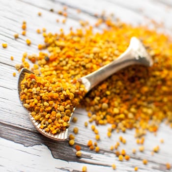 raw organic bee pollen over wooden board