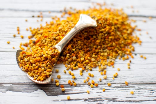 raw organic bee pollen over wooden board