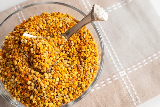 raw organic bee pollen over wooden board