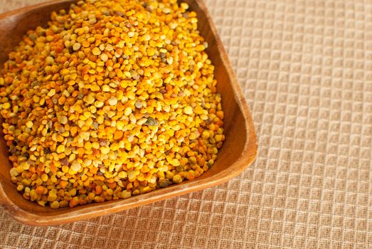 raw organic bee pollen over wooden board