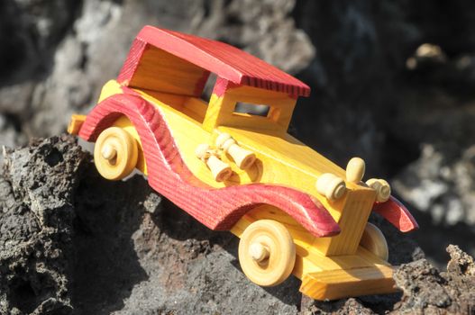 Transportation Concept Wooden Toy Car on the Rocks