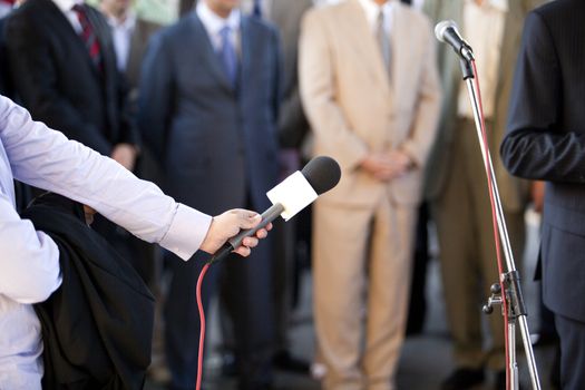 A journalist is making a interview with a microphone