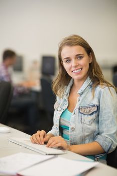 Happy young student studying in the computer room in college