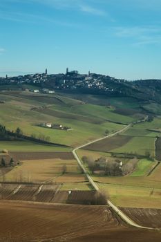 Landscape of hills with road cutting to town