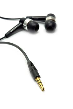 Audio jack and earphone on white (the focus is on the jack).
