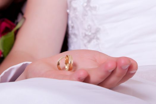 Photo man's hand on knee bride holding wedding rings