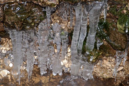 Detail of icicles on rocks in frozen water