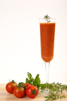 Tomatoes cold soup served on glass with basil