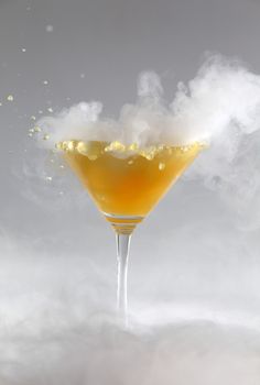 Vertical photo of a splash colored drink with smoke