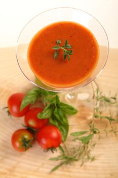 Tomatoes cold soup served on glass with basil