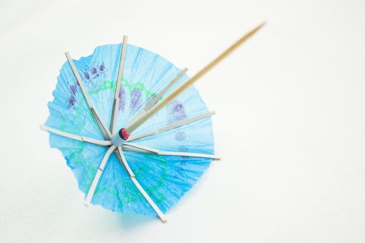 Different colors of cocktail umbrellas on a white background.