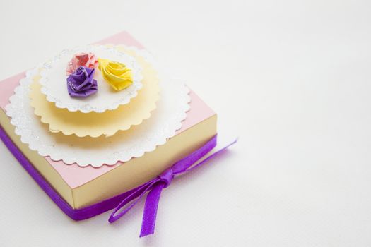 Handmake 3d origami gift box with different color roses on top.