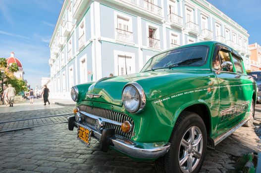 Cien Fuegos vintage car with building in background