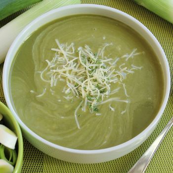 Bowl of green soup with cheese