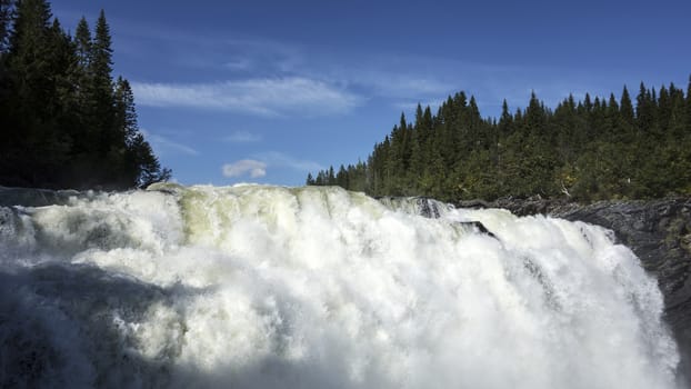 Beautiful mountain waterfall in sunny day with blue sky 