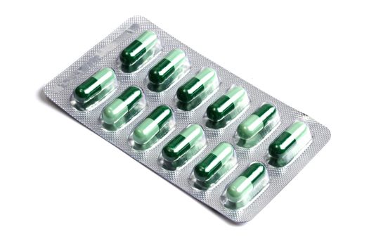 Package of green capsules isolated on white background 