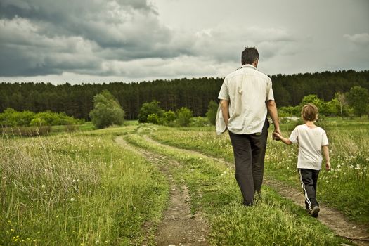 boy and his father are on the road away