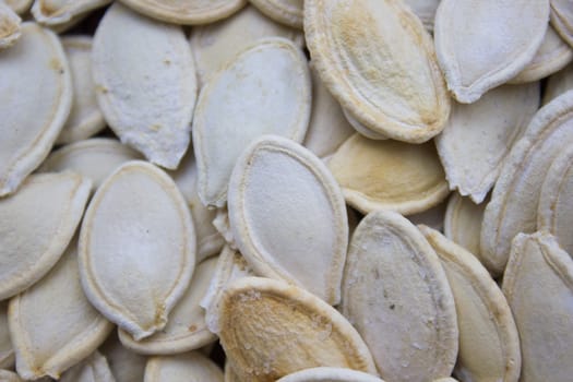 Closeup on toasted pumpkin seeds laying around.