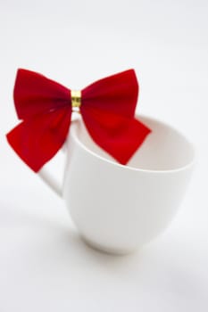 Isolated white cup with red and gold ribbon on top. 