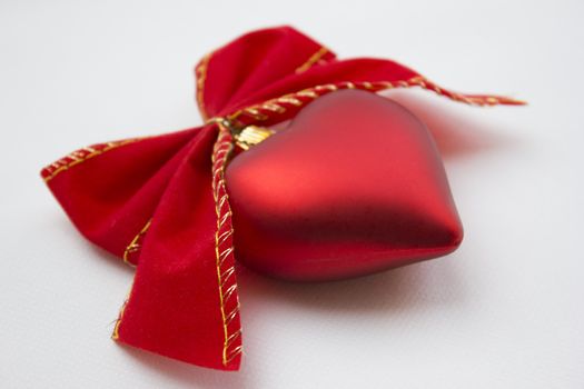 Heart shaped decoration with ribbons around it.