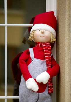 One big christmas doll outdoor at the window