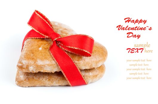 Heart shaped cookie tied with red ribbon on white