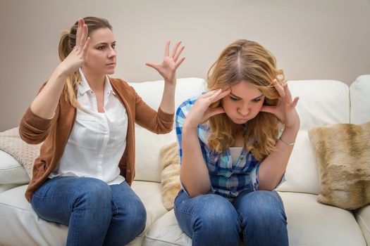 Furious young mother in a discussion with her teenage daughter. Problems between generations concept