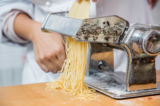 Chief making pasta with a machine